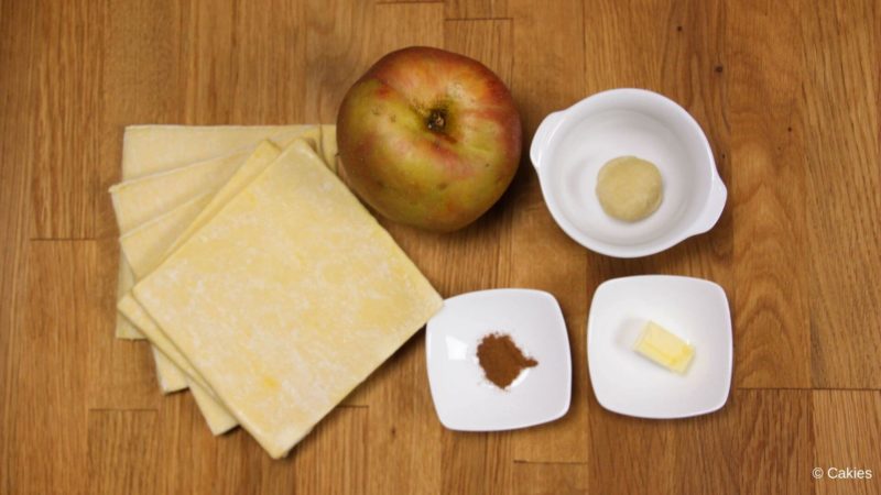 Ingredients for Dutch apple beignets with puff pastry on a wooden surface.